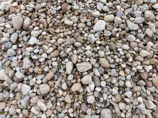 Multi-colored pebbles, medium-sized stones. Close-up view from above.