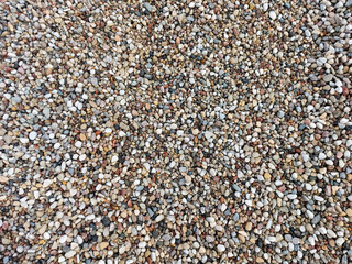 Multi-colored pebbles, medium-sized stones. Close-up view from above.