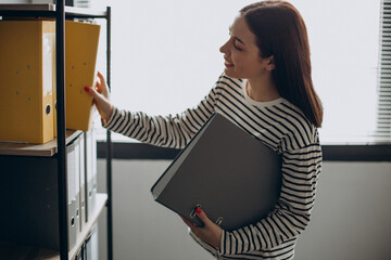 Young woman working with documents and checking archives