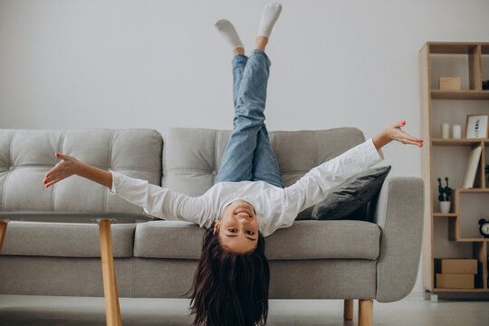 Woman relaxing while robot vacuum cleaner cleaning up the room
