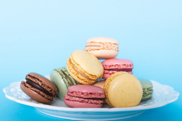 Colorful macaroons on a blue background. Delicious French almond dessert cookies. 