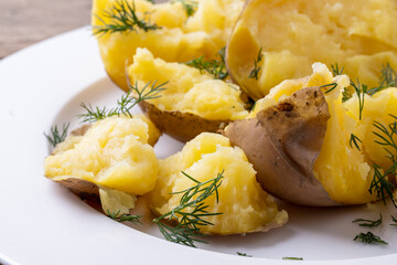 boiled potatoes on a white plate and wooden table