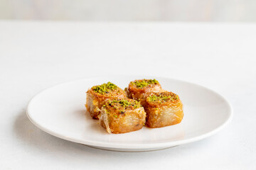 Pistachio baklava dessert on a white background. Turkish sweet dessert concept. plate of pistachio baklava. sherbet sweet Mediterranean bakery. close up. selective focus.