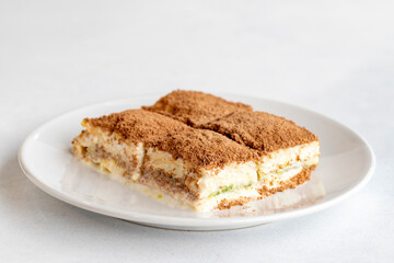 Cold baklava on a dark background. Turkish sweet dessert concept. plate of sliced forest fruit cake. Plate of cold milk baklava. Mediterranean bakery. close up. selective focus. soguk baklava