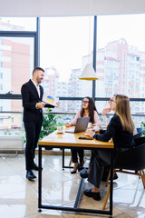 Successful meeting of business people, discussing new business ideas, using diagrams, sitting together. Modern office background. Meeting of business partners at the conference on business development