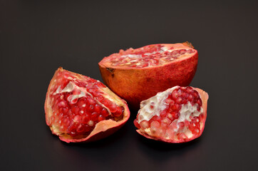 bright red pomegranate with seeds on a black close up