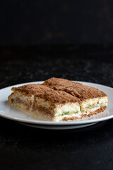 Cold baklava on a dark background. Turkish sweet dessert concept. plate of sliced forest fruit cake. Plate of cold milk baklava. Mediterranean bakery. close up. selective focus. soguk baklava
