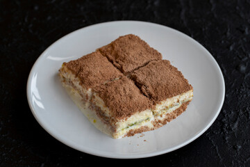 Cold baklava on a dark background. Turkish sweet dessert concept. plate of sliced forest fruit cake. Plate of cold milk baklava. Mediterranean bakery. close up. selective focus. soguk baklava