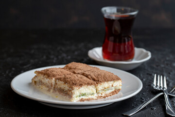 Cold baklava on a dark background. Turkish sweet dessert concept. plate of sliced forest fruit cake. Plate of cold milk baklava. Mediterranean bakery. close up. selective focus. soguk baklava