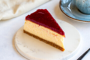 Cheesecake on white background. Greek sweet dessert concept. plate of sliced cheesecake. Cheesecake with raspberry gel filling. Mediterranean bakery. close up. selective focus. Horizontal view.