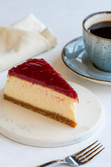 Cheesecake on white background. Greek sweet dessert concept. plate of sliced cheesecake. Cheesecake with raspberry gel filling. Mediterranean bakery. close up. selective focus. Vertical view.