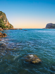 Knysna lagoon's east and west heads and rocky beach during sunset