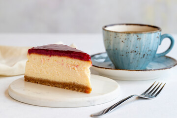 Cheesecake on white background. Greek sweet dessert concept. plate of sliced cheesecake. Cheesecake with raspberry gel filling. Mediterranean bakery. close up. selective focus. Horizontal view.