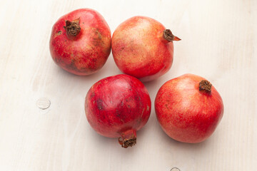 Fototapeta na wymiar pomegranates fruits arranged on light wooden background