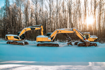 Construction site with big yellow excavators, tractor maсhines, digging equipment with ladles, hard tracked vehicles
