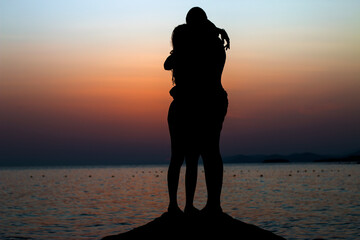 A couple in love on the seashore at sunset