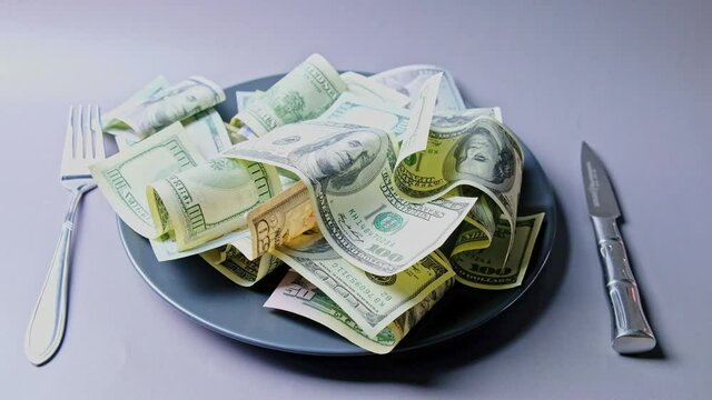 U.S. dollars served on a plate with knife and fork.