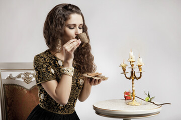 girl drinks tea. gray background. candlestick stands on a table