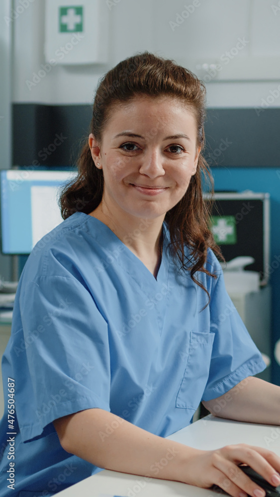 Poster portrait of nurse using computer for appointments with patient in doctors office. woman working as m