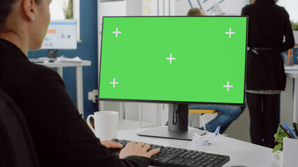 Close up of computer with horizontal green screen on desk. Woman with business job working on...