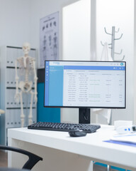 Empty doctors office having computer with patients files on screen standing on table during medical consultation. Hospital workplace equipped with professional instruments. Health care service support