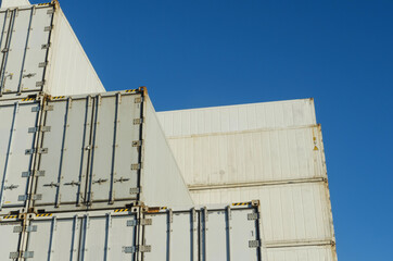 Stacks of white shipping containers viewed from below
