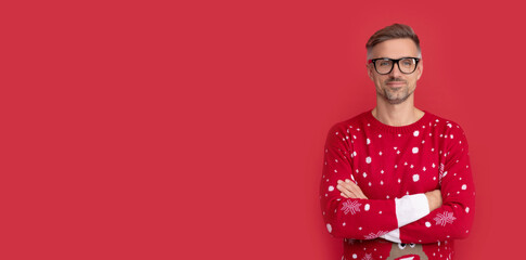 merry christmas. smiling man in winter sweater and glasses. xmas guy on red background.
