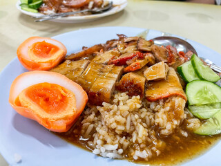 Crispy belly pork on rice with barbecue red sauce and Egg topped. It is a delicious menu of Thai. Close up photo.