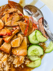 Crispy belly pork on rice with barbecue red sauce and Egg topped. It is a delicious menu of Thai. Close up photo.