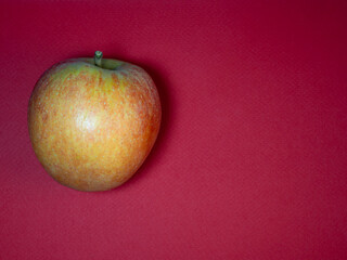 Big red apple on a purple background.The product is on the table. Fresh ripe fruits.