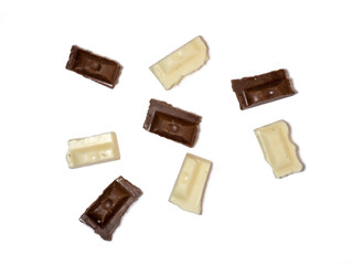 Slices of black and white chocolate on a white background. Various chocolates on the table.