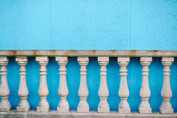 White stone balustrade in classical style near the blue wall