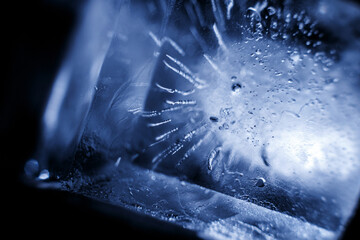 Crystal ice cubes reflection on black background. Extreme close up natural ice block on dark backdrop. Macro.
