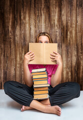 Teenage girl sitting with a stack of books