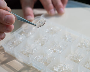 Installation of nose pads in glasses. A male technician repairs broken glasses