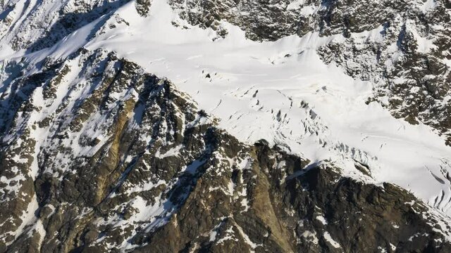 Panorama shot of massive snow-covered mountains lighting by sun at Mueller Hut Route,New Zealand