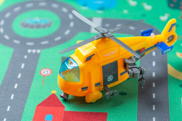 町の広場に着陸した黄色いヘリコプターの模型
