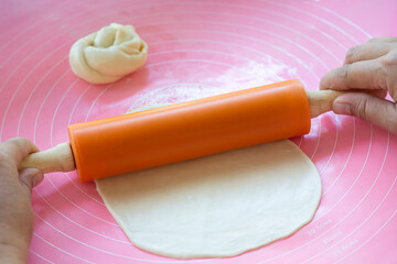Housewives use dough rollers to make roti or steamed buns.