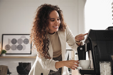 African American woman preparing fresh aromatic coffee with modern machine in office