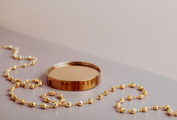 Golden podium with a new year decoration on a beige background. New Year's platform. Copy space. Festive background.