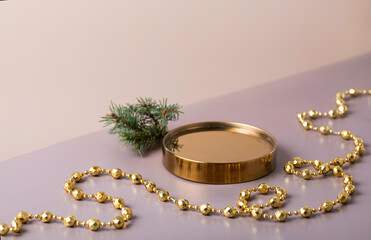 Golden podium with a spruce branch on a beige background. New Year's platform. Copy space. Festive...