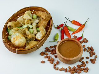 batagor or fried dumplings and peanut sauce with cayenne pepper and scattered peanuts.