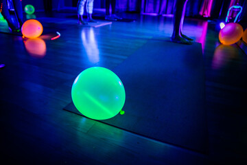 Glowing Balloon In Blacklight Yoga Class