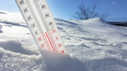 The thermometer in winter lies on the snow and shows low negative air temperature. Meteorological conditions in the harsh climate in the northern regions and the environment.Climate change on Earth