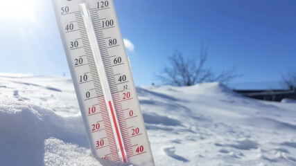 Thermometer in winter in the cold on snow and analyzes low negative air temperatures in clear sunny weather.Meteorological conditions and environmental analysis.Climate change on earth.Northern region