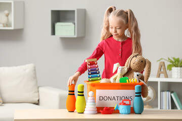 Cute little girl sorting donation box at home