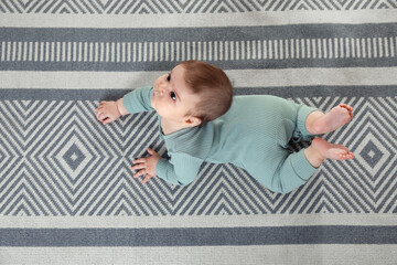 Naklejka premium Cute baby crawling on floor, top view