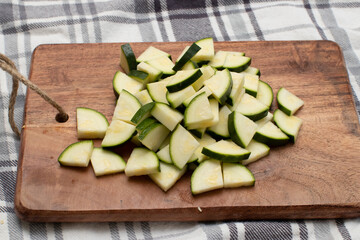 Cut up zucchini on a wooden cutting board in the kitchen