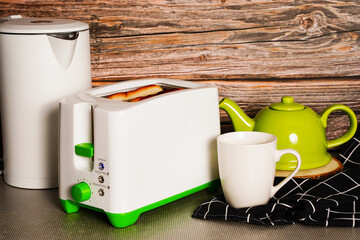 White kettle and toaster mockup stand on a kitchen table on a wooden wall background