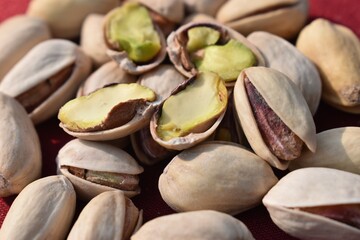 Green fresh pistachios Nuts on red background